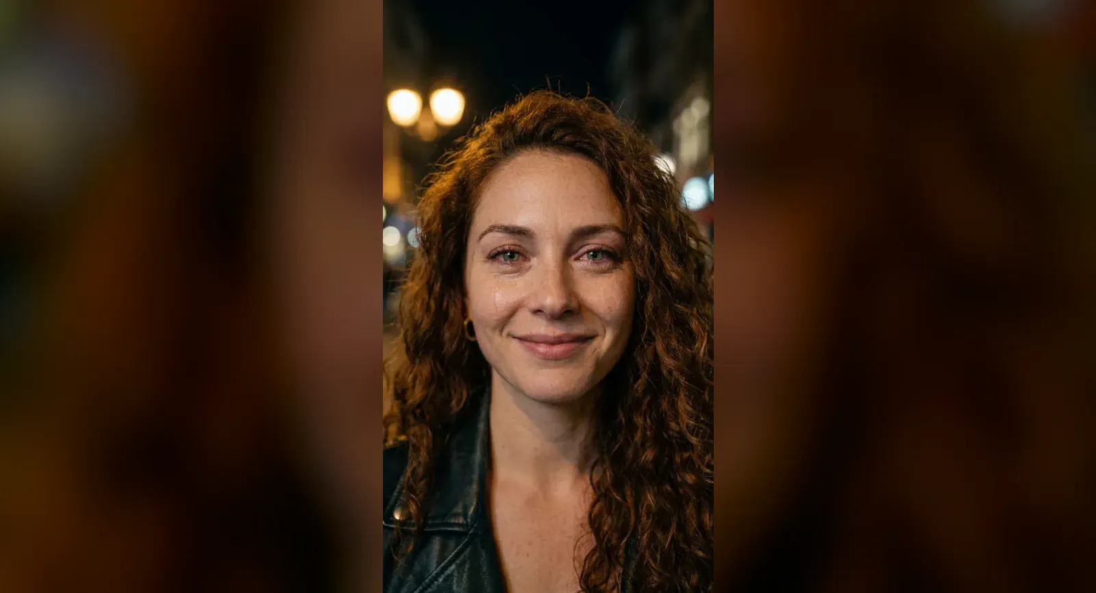 Lena, one of eroq's fictional characters, on a city street at night under warm streetlamps, smiling softly at the camera with a tear running down her cheek.
